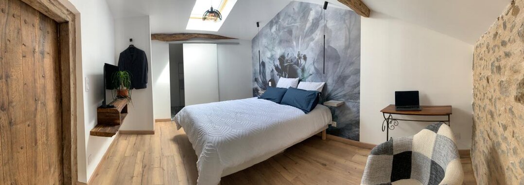 La chambre Hibiscus Un aperçu de la chambre Hibiscus, mettant en avant un lit et un mural vibrant.